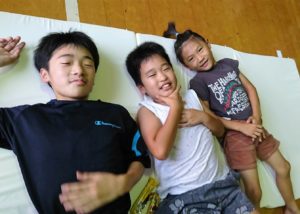 マットレスを受け取った杷木中学校に避難する子どもたち