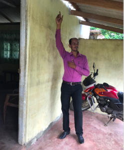 District staff pointing flood level