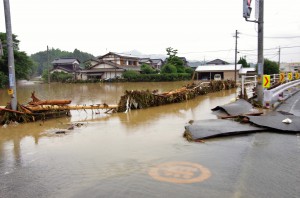 冠水し、アスファルトがめくれた道路、