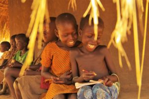 木陰で絵をかいて遊ぶ子どもたち