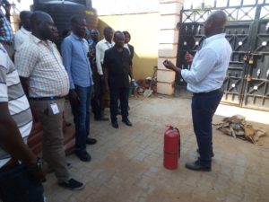 消火器の説明を受けるスタッフたち